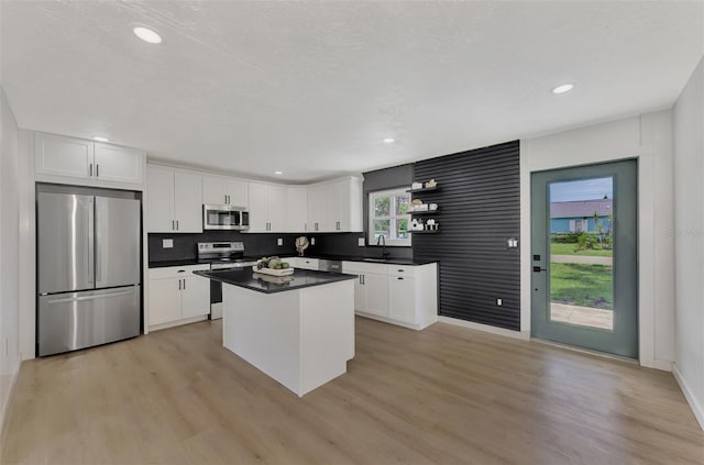 kitchen featuring a center island, light hardwood / wood-style flooring, stainless steel appliances, white cabinetry, and sink