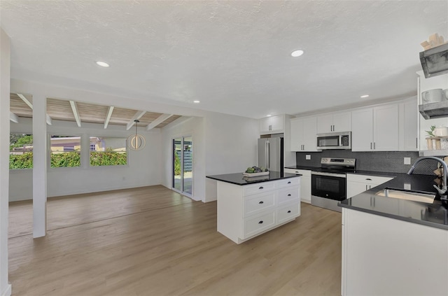 kitchen featuring white cabinets, a healthy amount of sunlight, stainless steel appliances, and sink