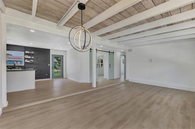 unfurnished living room with a barn door, beamed ceiling, wooden ceiling, and light hardwood / wood-style flooring