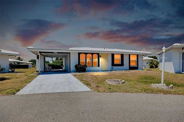 view of front facade with a lawn and a carport