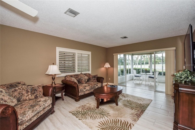 living area featuring visible vents and a textured ceiling