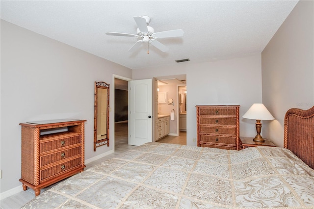 bedroom with baseboards, visible vents, ensuite bath, and a ceiling fan