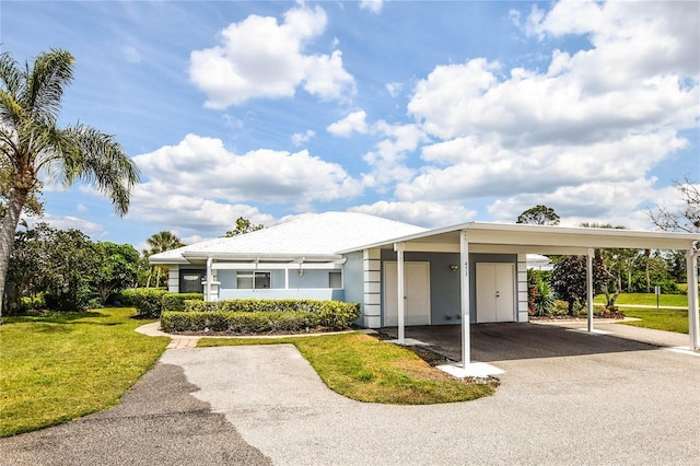 view of front of property featuring aphalt driveway, an attached carport, and a front lawn