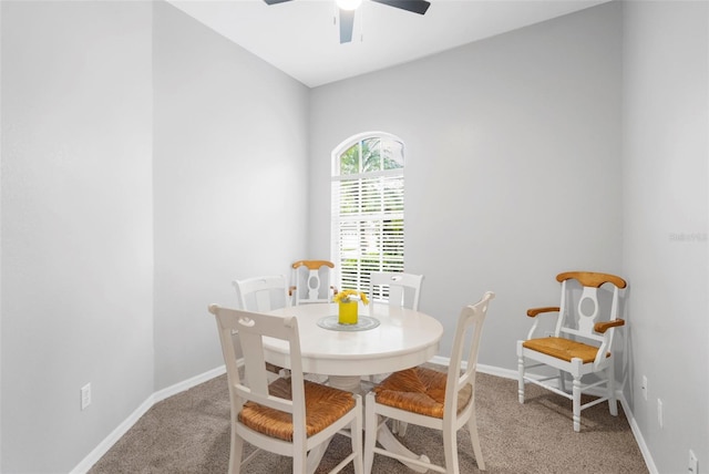 dining room with a ceiling fan, light carpet, and baseboards