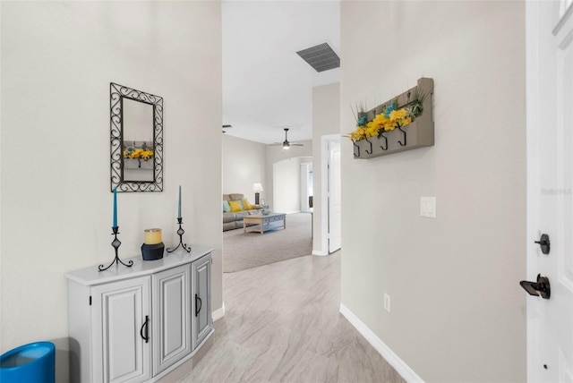 hallway with visible vents and baseboards