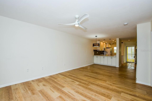 unfurnished living room with light hardwood / wood-style flooring and ceiling fan