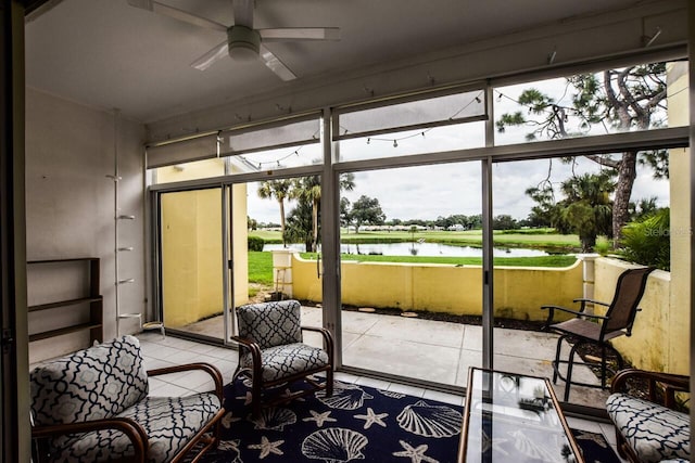 sunroom / solarium with a water view and ceiling fan