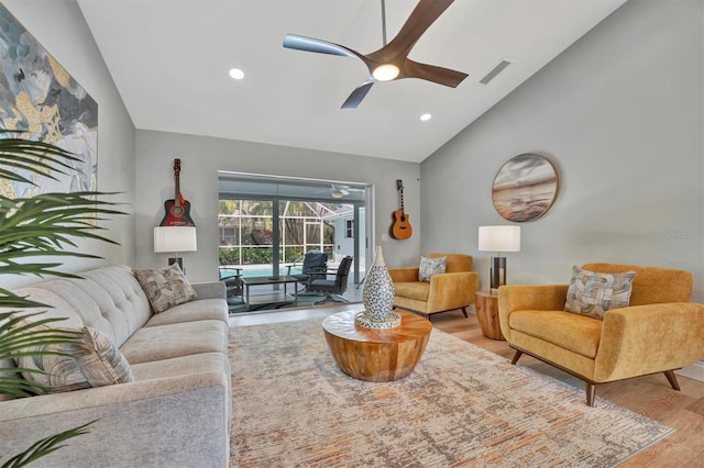 living room featuring lofted ceiling, light hardwood / wood-style flooring, and ceiling fan