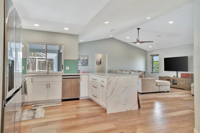 kitchen featuring white cabinets, dishwasher, light hardwood / wood-style floors, lofted ceiling, and ceiling fan