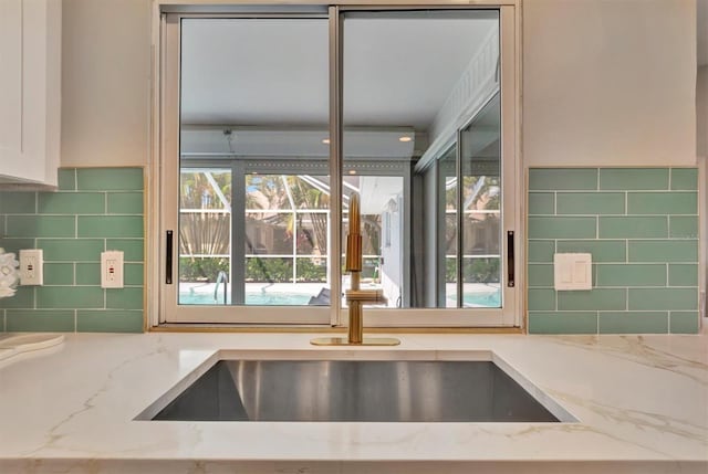 kitchen with light stone counters and sink