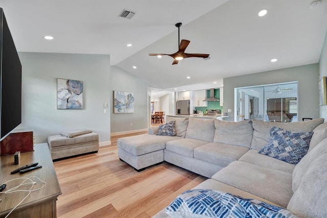 living room with lofted ceiling, ceiling fan, and light hardwood / wood-style floors