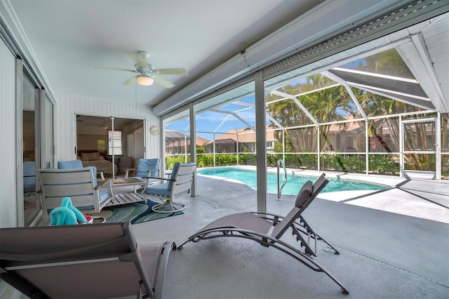 view of swimming pool with ceiling fan, a patio, and a lanai