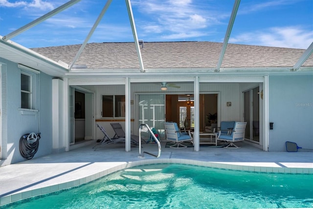 view of pool featuring glass enclosure, ceiling fan, and a patio area