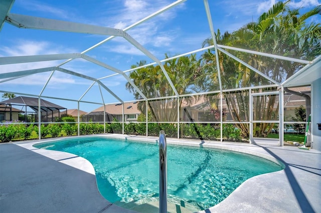 view of swimming pool featuring glass enclosure and a patio area