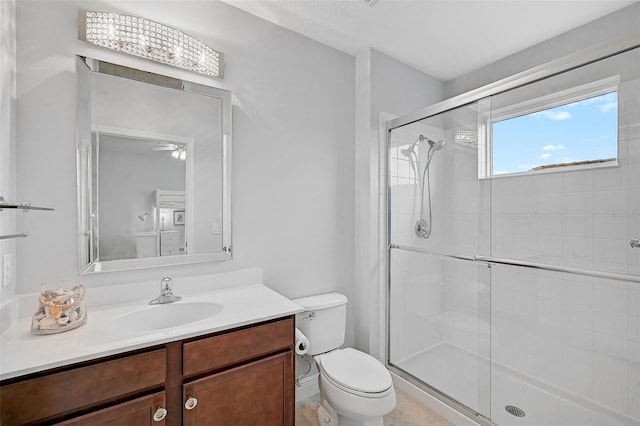 bathroom featuring vanity, toilet, and a shower with shower door