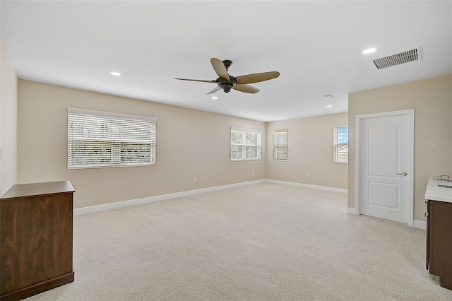 spare room with light colored carpet and ceiling fan