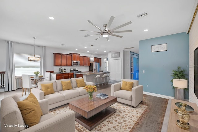 living room with ceiling fan with notable chandelier