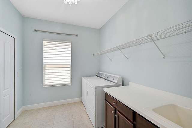 laundry room with sink, cabinets, washer and dryer, and light tile patterned flooring