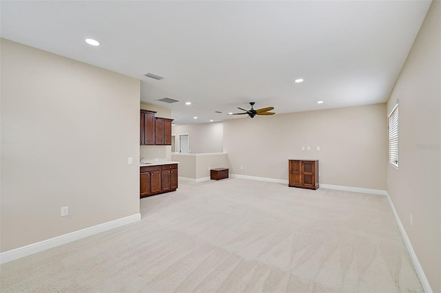 unfurnished living room featuring ceiling fan and light colored carpet