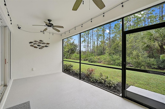 unfurnished sunroom featuring ceiling fan