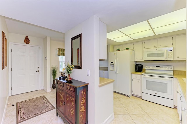 kitchen with white appliances and light tile patterned flooring