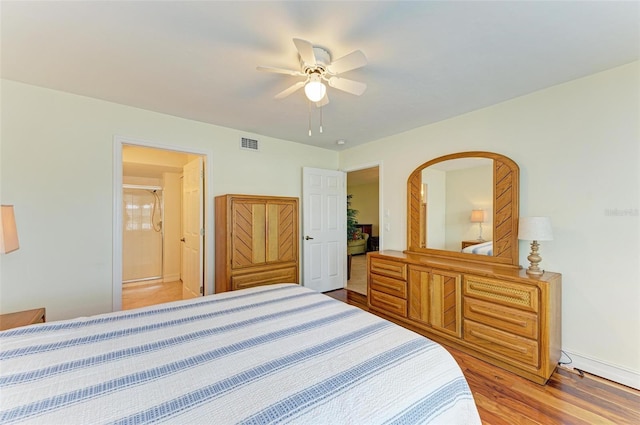 bedroom featuring wood-type flooring, ensuite bathroom, and ceiling fan