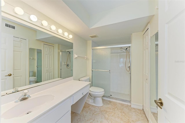 bathroom featuring tile patterned flooring, vanity, toilet, and walk in shower