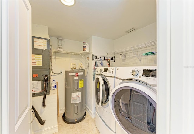 laundry area with electric water heater, light tile patterned floors, and washing machine and clothes dryer