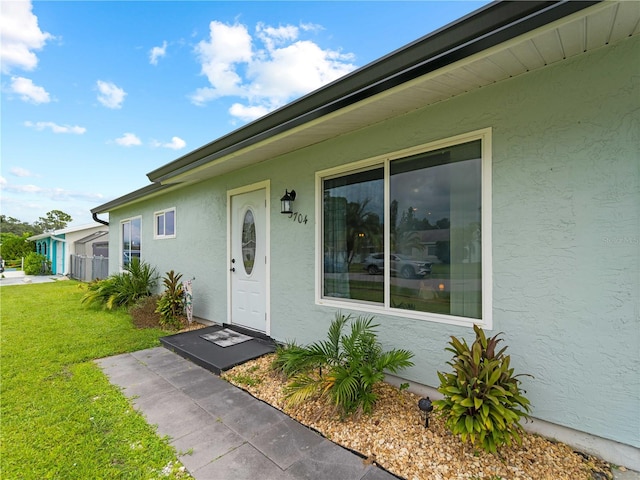 entrance to property featuring a lawn