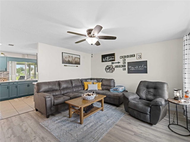 living room featuring light hardwood / wood-style floors, sink, and ceiling fan