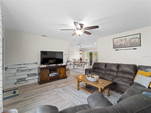 living room featuring ceiling fan and light hardwood / wood-style flooring