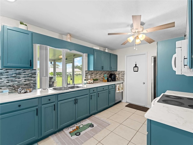 kitchen with decorative backsplash, white appliances, light tile patterned floors, ceiling fan, and sink