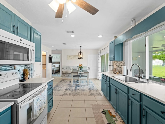 kitchen with ceiling fan, light tile patterned floors, sink, white appliances, and backsplash