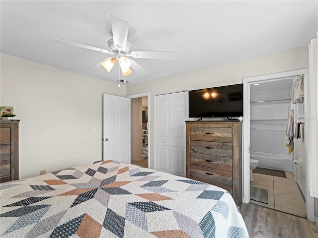 bedroom featuring connected bathroom, ceiling fan, light hardwood / wood-style flooring, and a closet