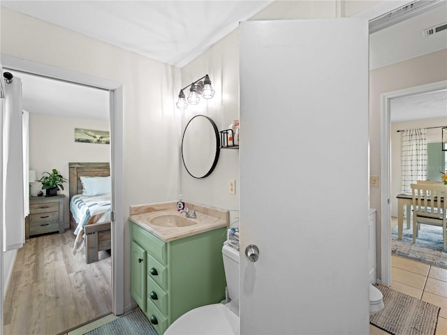 bathroom featuring wood-type flooring, vanity, and toilet