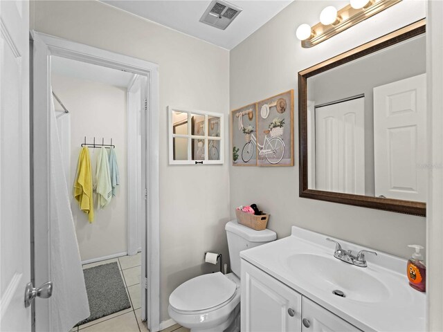 bathroom with tile patterned flooring, vanity, and toilet