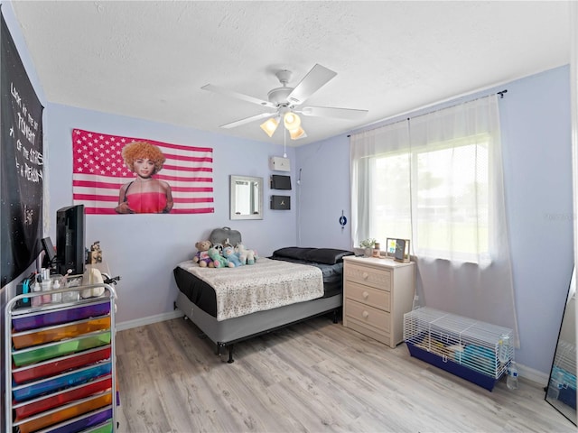 bedroom featuring a textured ceiling, ceiling fan, and light hardwood / wood-style flooring