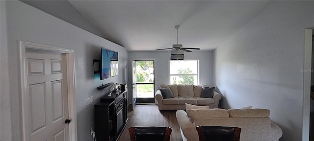 living room with ceiling fan, dark hardwood / wood-style floors, and vaulted ceiling