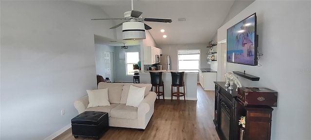 living room with vaulted ceiling, wood-type flooring, and ceiling fan