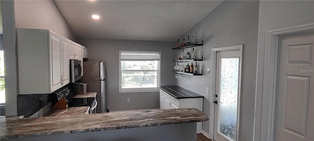 kitchen featuring plenty of natural light, kitchen peninsula, stainless steel appliances, and white cabinets