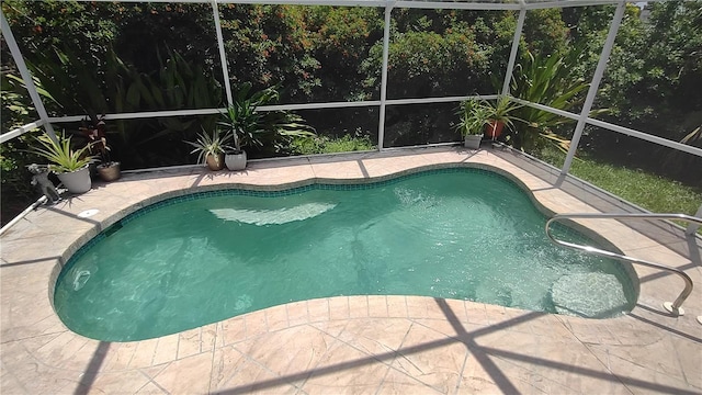 view of swimming pool featuring a patio area and glass enclosure