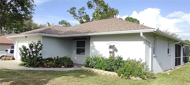 view of side of property with a yard and a garage