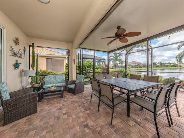 sunroom / solarium with a water view and ceiling fan