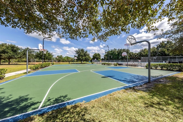 view of sport court with a lawn