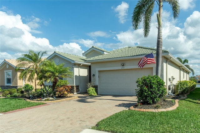 mediterranean / spanish-style home featuring a garage and a front yard