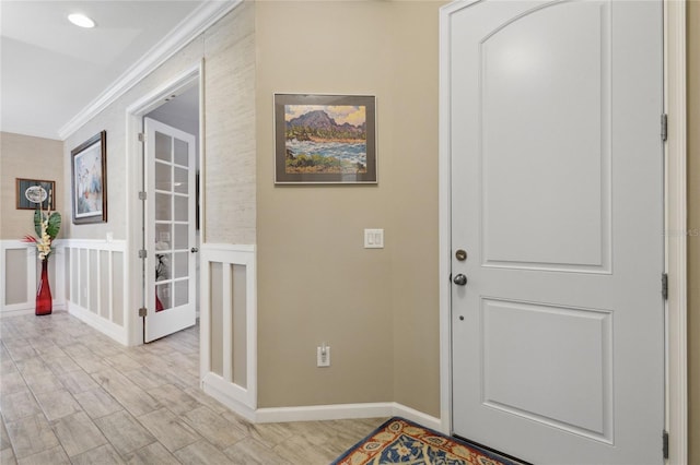 foyer entrance featuring light hardwood / wood-style flooring and crown molding