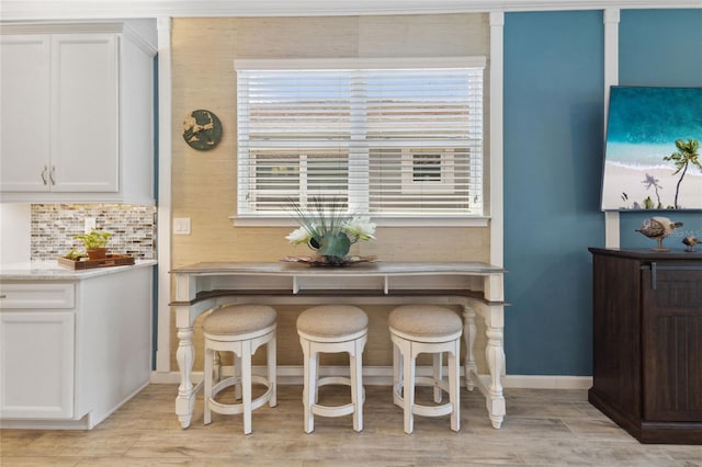 dining room featuring light wood-style flooring and baseboards