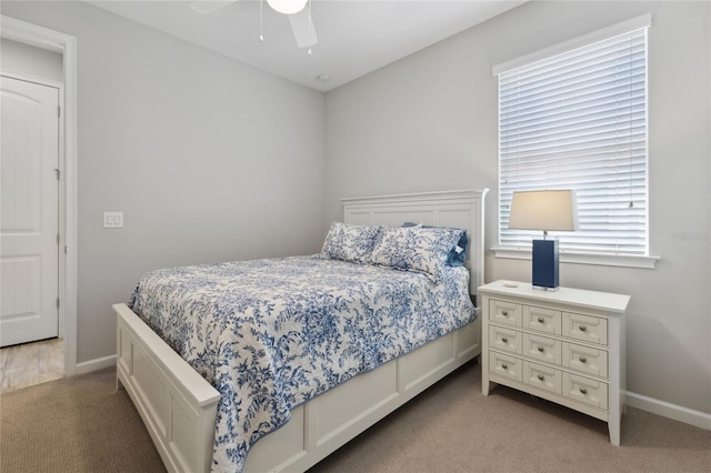 bedroom featuring light carpet, baseboards, and a ceiling fan