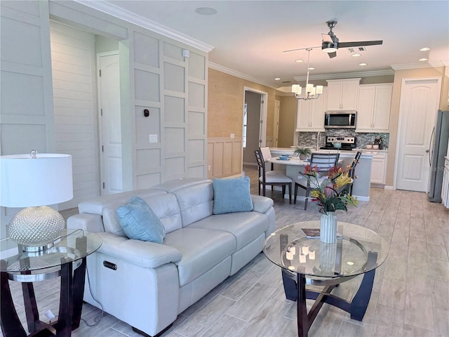 12000 Tapestry Ln, Venice, FL 34293 - living area with crown molding, a wainscoted wall, recessed lighting, light wood finished floors, and a notable chandelier
