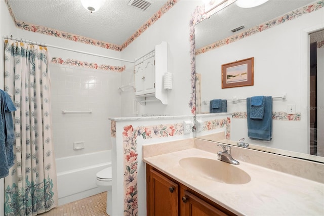 full bathroom featuring tile patterned flooring, toilet, shower / bath combo with shower curtain, vanity, and a textured ceiling